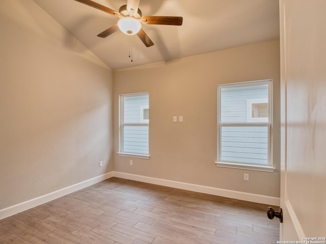 unfurnished room with lofted ceiling, wood finished floors, a ceiling fan, and baseboards