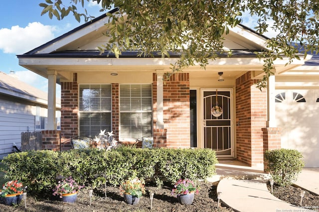 entrance to property featuring covered porch, brick siding, and an attached garage