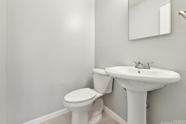 bathroom featuring tile patterned flooring, toilet, and baseboards