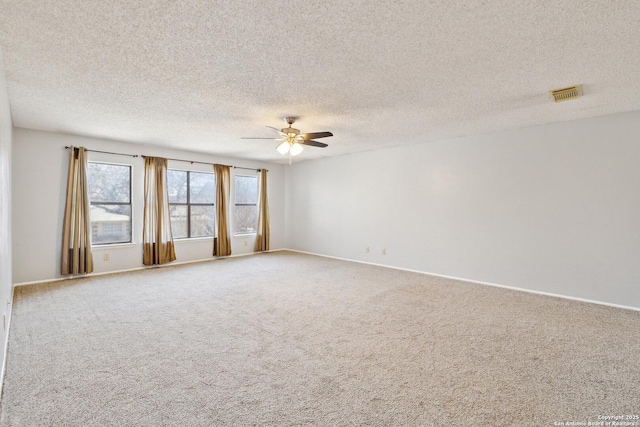 carpeted empty room with baseboards, a textured ceiling, visible vents, and a ceiling fan