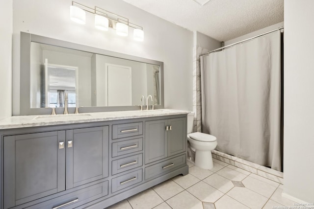 bathroom featuring double vanity, toilet, tile patterned floors, a textured ceiling, and a sink