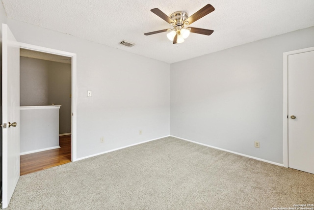 unfurnished bedroom with visible vents, a ceiling fan, carpet flooring, a textured ceiling, and baseboards