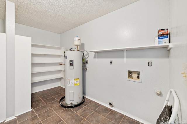 clothes washing area with hookup for a washing machine, electric water heater, laundry area, dark tile patterned flooring, and electric dryer hookup