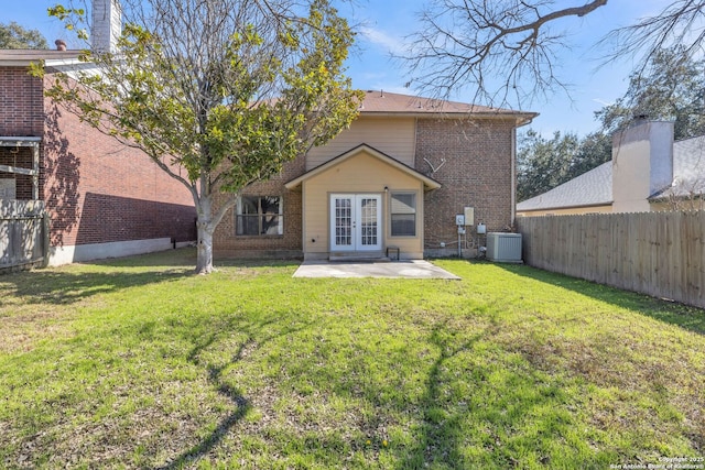 back of house featuring a yard, french doors, fence, and brick siding