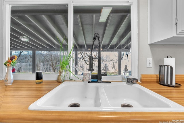 room details featuring white cabinets, a sink, and light countertops