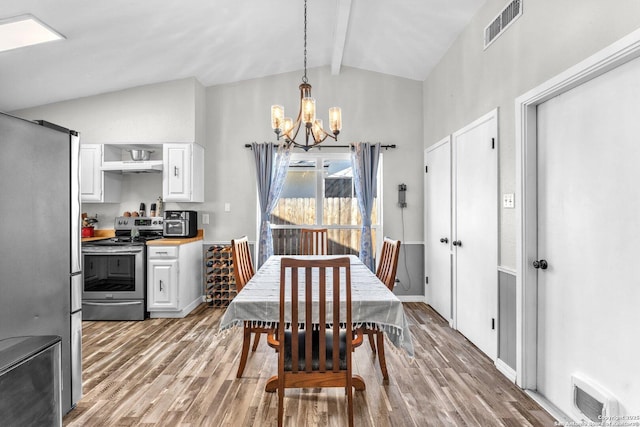 dining room featuring vaulted ceiling with beams, light wood-type flooring, and visible vents