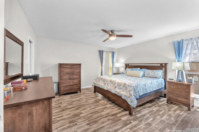 bedroom featuring wood finished floors, a ceiling fan, and baseboards