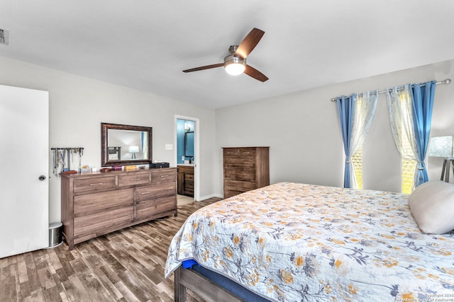 bedroom with a ceiling fan, visible vents, ensuite bath, and wood finished floors