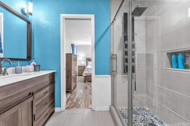 bathroom featuring a stall shower, ensuite bath, and vanity