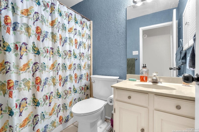 full bath featuring a shower with curtain, a textured wall, vanity, and toilet