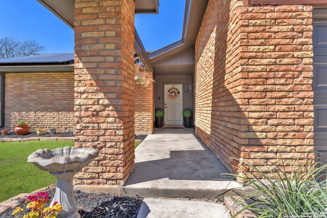 entrance to property with brick siding and solar panels