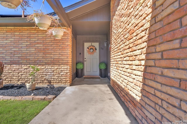 property entrance featuring brick siding