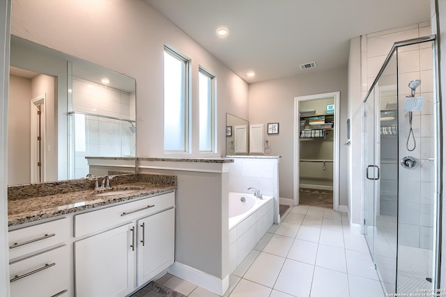 full bathroom with a garden tub, a shower stall, a spacious closet, and visible vents