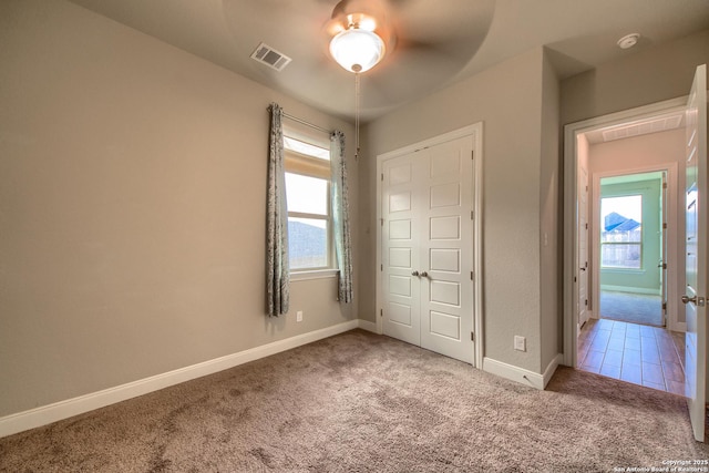 unfurnished bedroom featuring carpet, visible vents, and baseboards