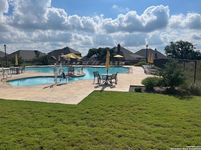 pool with a yard, a patio area, and fence