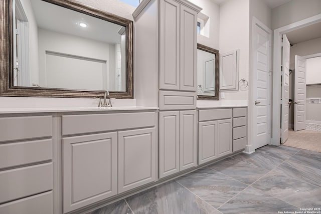 full bath with marble finish floor and vanity