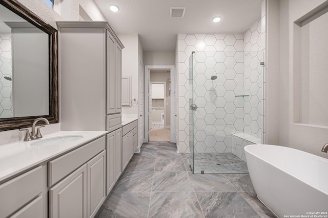 bathroom with vanity, visible vents, marble finish floor, a soaking tub, and a stall shower