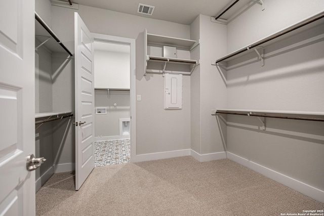 spacious closet featuring light colored carpet, electric panel, and visible vents