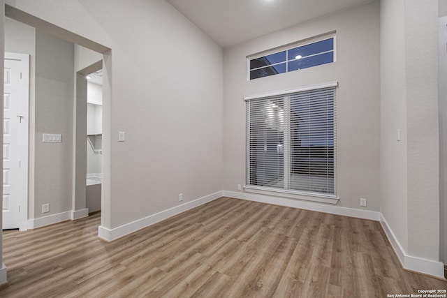 empty room featuring light wood-type flooring and baseboards