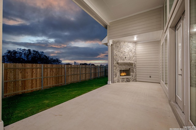 view of patio with fence and an outdoor stone fireplace