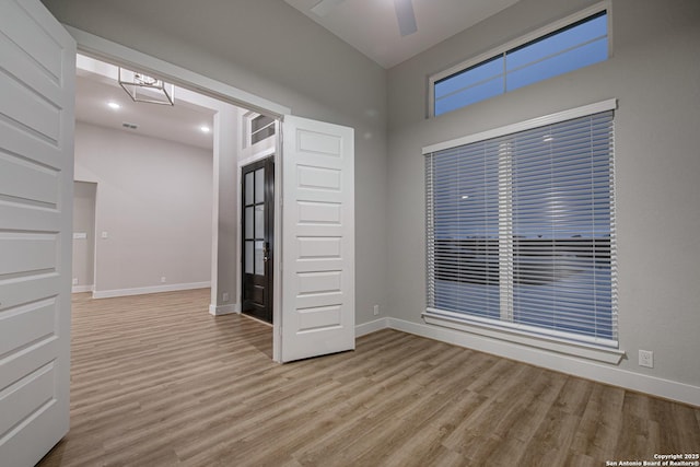 unfurnished room featuring ceiling fan, baseboards, and wood finished floors