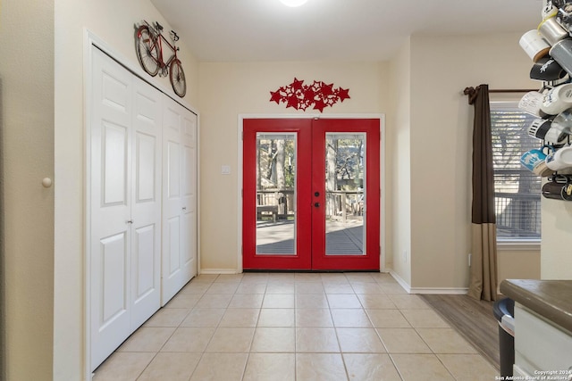 entrance foyer featuring french doors, baseboards, and light tile patterned floors