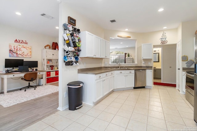 kitchen with a sink, white cabinetry, visible vents, and stainless steel dishwasher