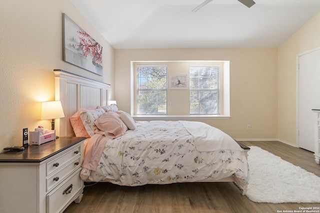 bedroom with a ceiling fan, baseboards, and wood finished floors