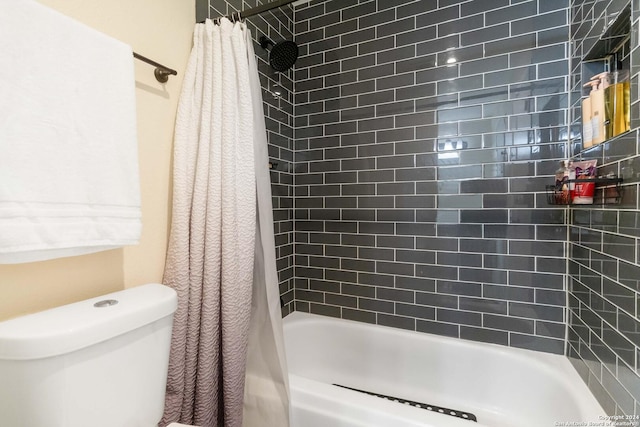 bathroom featuring shower / bath combination with curtain and toilet