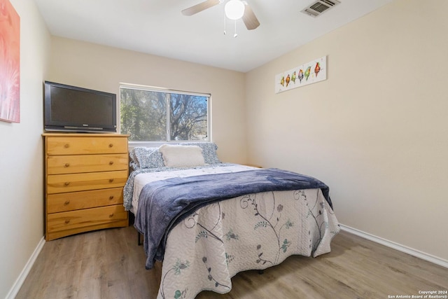 bedroom with visible vents, ceiling fan, baseboards, and wood finished floors