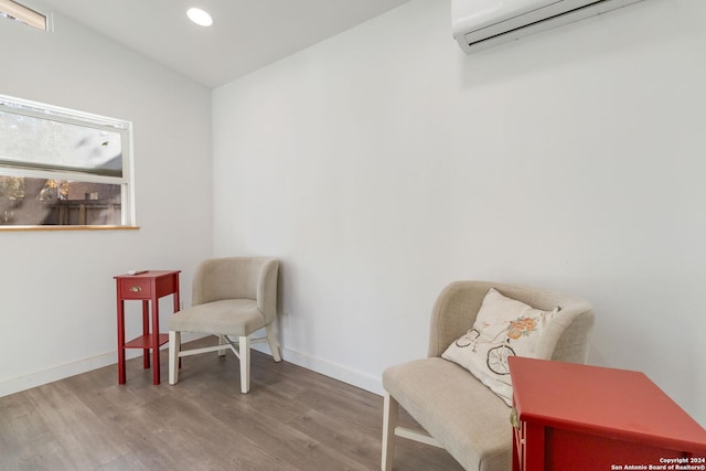 sitting room with recessed lighting, baseboards, wood finished floors, and a wall mounted AC