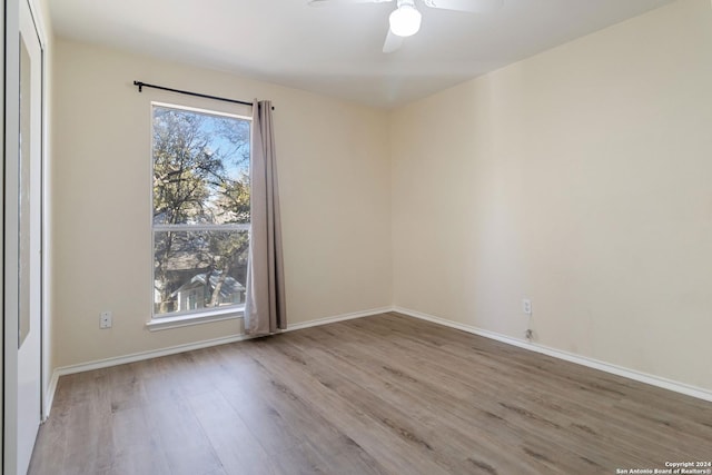 unfurnished room with a healthy amount of sunlight, baseboards, and wood finished floors