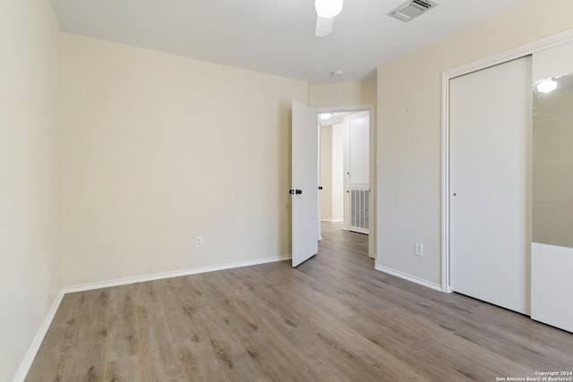 unfurnished bedroom featuring wood finished floors, visible vents, and baseboards