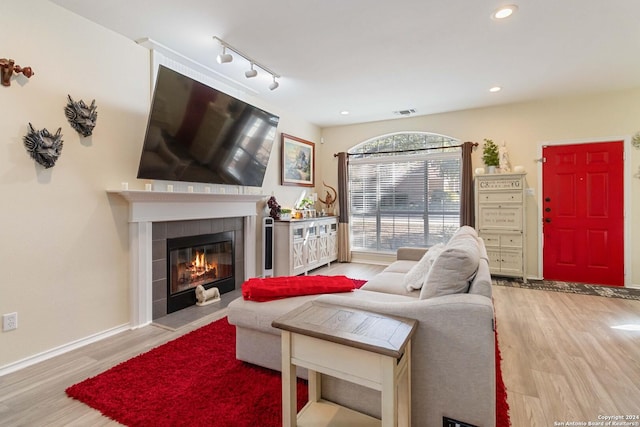 living room featuring baseboards, a fireplace, wood finished floors, and recessed lighting