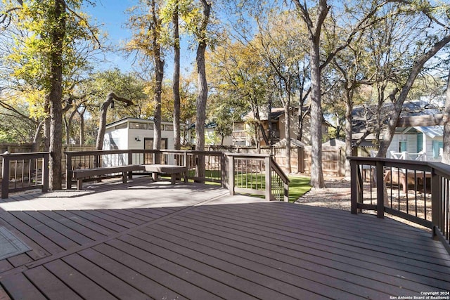 deck featuring an outdoor structure, fence, and a residential view