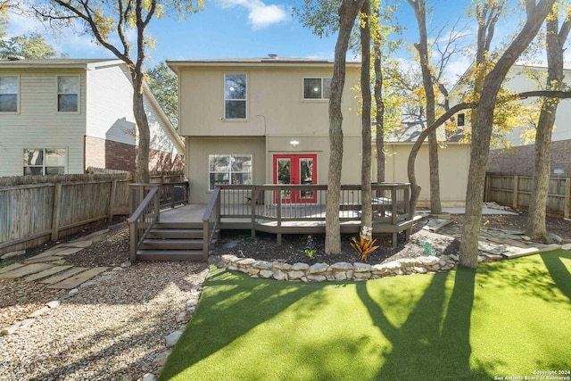 back of property with a lawn, a fenced backyard, a wooden deck, and stucco siding