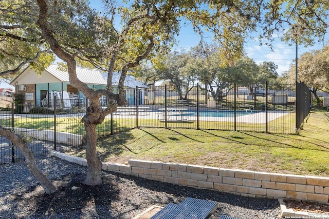 exterior space with fence, a pool, and a yard