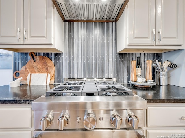 kitchen featuring custom exhaust hood, white cabinets, backsplash, and gas stove