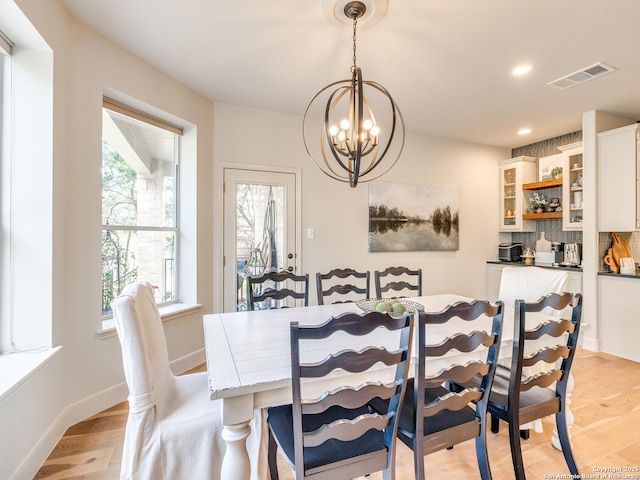 dining space with light wood-style flooring, recessed lighting, visible vents, baseboards, and an inviting chandelier