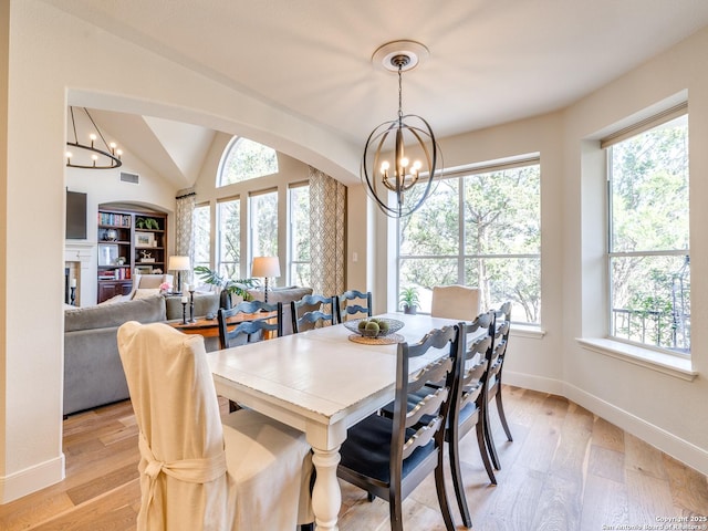 dining space featuring a chandelier, light wood-style flooring, and a healthy amount of sunlight