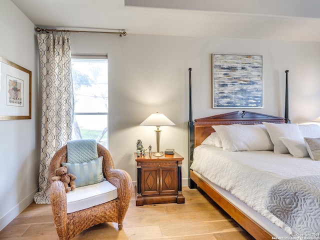 bedroom featuring light wood finished floors and baseboards