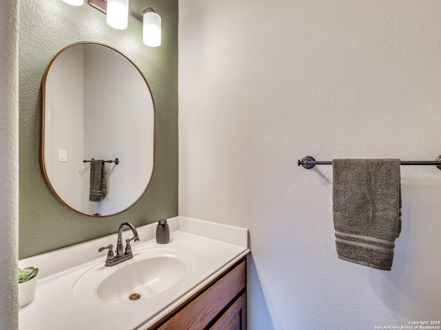 bathroom with a textured wall and vanity