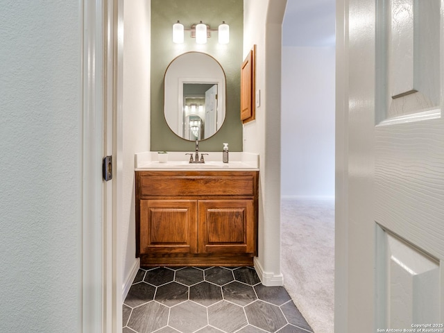 bathroom with a textured wall, vanity, and tile patterned floors