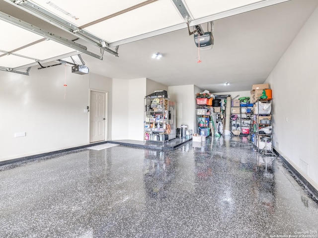 garage featuring a garage door opener and baseboards