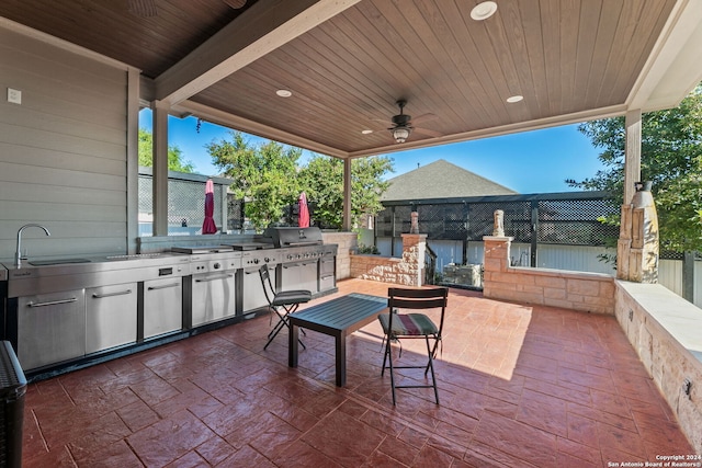 view of patio / terrace featuring exterior kitchen, fence, a sink, and ceiling fan