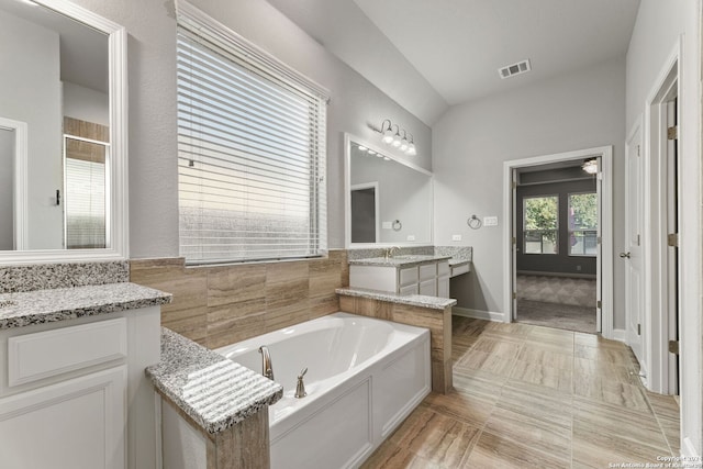 bathroom featuring visible vents, walk in shower, vanity, and a bath