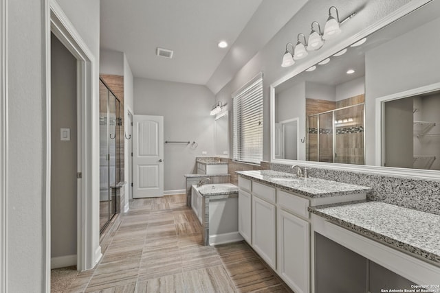 bathroom featuring two vanities, visible vents, a stall shower, a sink, and a bath