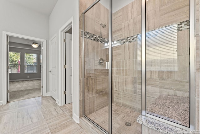 full bath with ceiling fan, a shower stall, and baseboards