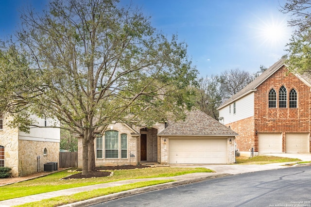 view of front facade featuring driveway, a shingled roof, a garage, and brick siding