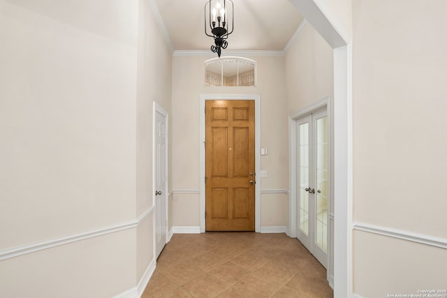 hallway with baseboards, crown molding, and light tile patterned flooring